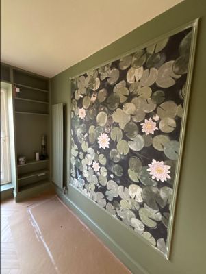 Green painted alcove shelving with lily pad feature wallpaper