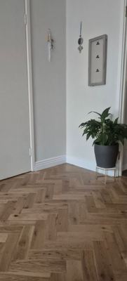 Herringbone wood flooring fitted in a hallway corner