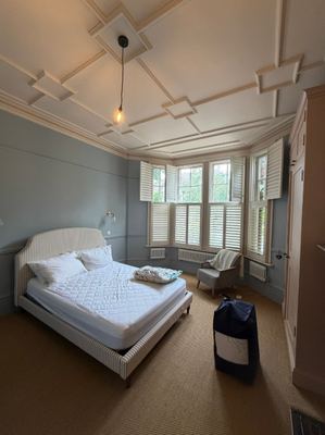 Bedroom renovation with ornate coved ceiling and shuttered bay window