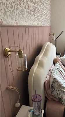 Pink wall panelling and floral wallpaper in a bedroom decorating project