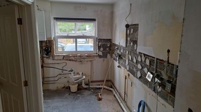 Property renovation strip-out showing exposed brickwork and plumbing
